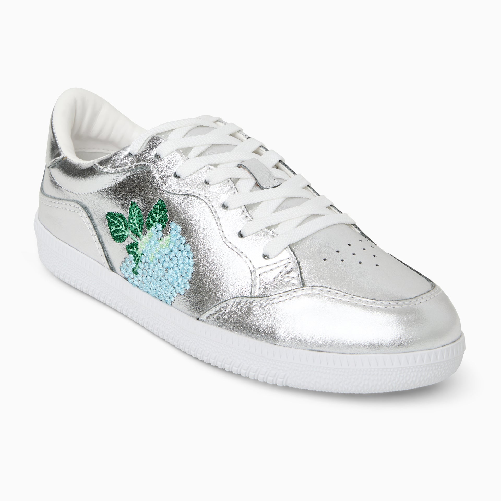 Stylish silver and white sneakers on a reflective surface, highlighting their fashion-forward design